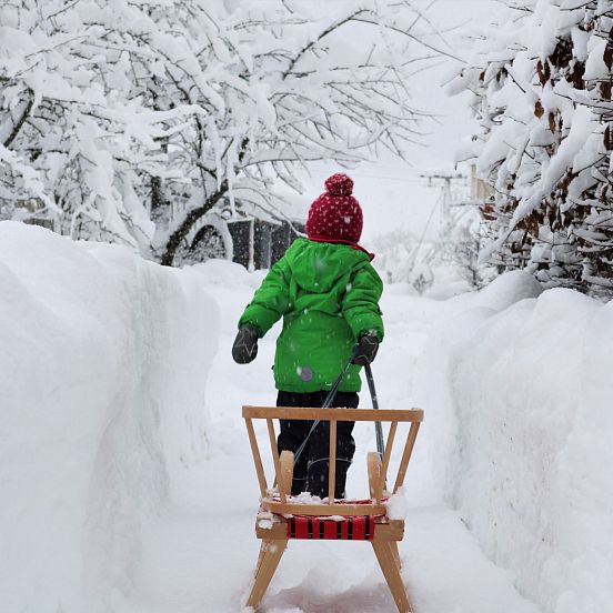 Winter child tobogganing Intersport Sturm (c) Salzburger Saalachtal Tourismus Author Bianca Baumgartner